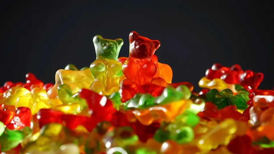 Gelébjörnar i rött, gult och grönt mot mörk bakgrund